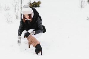 il ragazza passeggiate con un' cane nel il inverno. foto