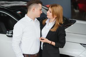 giovane coppia comprando un' auto nel un' auto showroom. foto