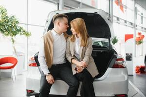 giovane coppia comprando un' auto nel un' auto showroom. foto