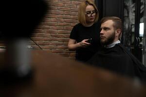 professionale parrucchiere donna fare messa in piega di bello tipo con elettrico capelli clipper a barbiere negozio. foto