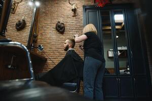 barbiere donna taglio uomo capelli a il barbiere. donna Lavorando come un' parrucchiere. piccolo attività commerciale concetto foto