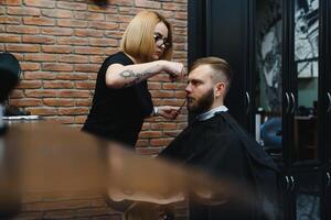 professionale parrucchiere donna fare messa in piega di bello tipo con elettrico capelli clipper a barbiere negozio. foto