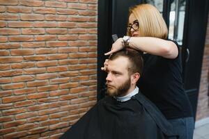 barbiere donna taglio uomo capelli a il barbiere. donna Lavorando come un' parrucchiere. piccolo attività commerciale concetto foto