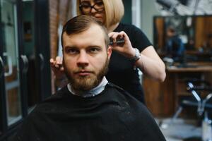 barbiere donna taglio uomo capelli a il barbiere. donna Lavorando come un' parrucchiere. piccolo attività commerciale concetto foto