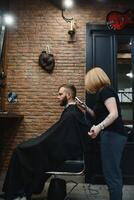 barbiere donna taglio uomo capelli a il barbiere. donna Lavorando come un' parrucchiere. piccolo attività commerciale concetto foto