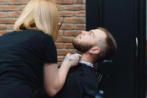 cliente durante barba rasatura nel barbiere negozio foto