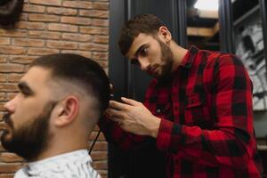 barbiere negozio. uomo con moglie nel del barbiere sedia, parrucchiere barbiere messa in piega il suo capelli. foto