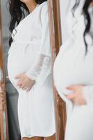 incinta donne toccante sua pancia con mano foto