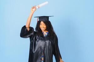 afroamericano bellissimo donna nel un' nero accappatoio e cappello, su un' blu isolato sfondo sorrisi. foto