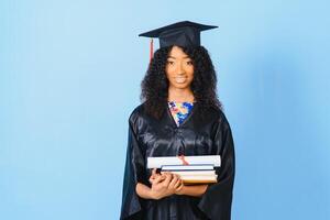 giovane afroamericano alunno nel laurea breve accappatoio su colore sfondo foto