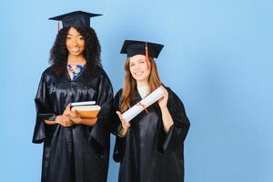 Due giovane donne festeggiare loro la laurea con diplomi foto