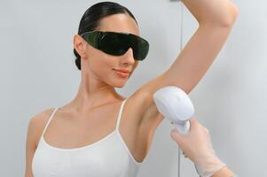 giovane donna fabbricazione corpo capelli rimozione laser depilazione nel bellezza centro foto