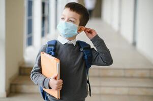 poco scolaro indossare un' maschera durante un scoppio di corona e influenza virus, protezione contro malattie per figli, maschera per il prevenzione di coronavirus. foto