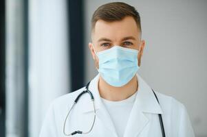 medico uomo mette su un' protettivo maschera foto