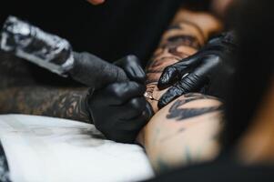 tatuatore con il suo macchina tatuaggio su il braccio con il design disegnato, concetto di arte e design foto