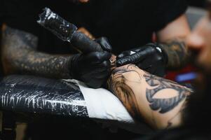 tatuaggio salone. il tatuaggio maestro è tatuaggio un' uomo. tatuaggio macchina, sicurezza e igiene a opera. avvicinamento, colorato, tatuatore. foto