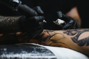 professionale tatuaggio artista Lavorando nel il suo tatuaggio studio. foto