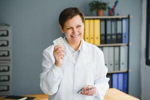 ritratto di esperto pensionato pensionato infezione specialista donna consultare corona virus paziente hold pillole bicchiere acqua indossare stetoscopio. foto