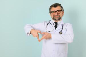 anziano medico uomo indossare stetoscopio e medico cappotto oltre blu sfondo foto