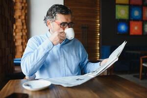 caffè rompere. uomo potabile caffè e lettura giornale nel bar bar foto