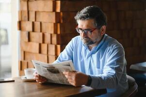 caffè rompere. uomo potabile caffè e lettura giornale nel bar bar foto