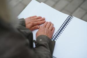 vecchio donna' S mani, lettura un' libro con braille linguaggio. foto