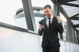 giovane uomo vestito formale godendo il suo successo. vincitore concetto foto