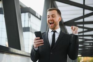 giovane uomo vestito formale godendo il suo successo. vincitore concetto foto