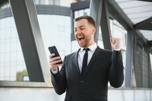 giovane uomo vestito formale godendo il suo successo. vincitore concetto foto