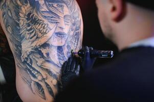 tatuaggio artista mani indossare guanti e Tenere un' tatuaggio macchina foto