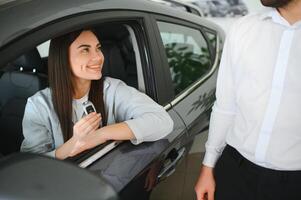 auto commerciante dando chiave per nuovo auto proprietario foto