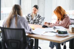 contento gruppo di amichevole studenti parlando, discutere nuovo scuola progetto idee insieme foto