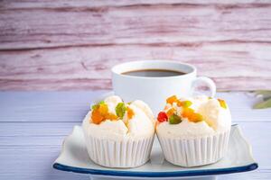 lato Visualizza di tailandese al vapore cupcakes sormontato con asciutto frutta su un' piatto e un' bianca caffè tazza con di legno parete sfondo. khanom pui fai nel tailandese foto