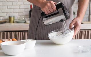 uomo indossare grembiule cucinando Tiramisù a cucina foto