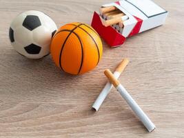 fumo o gli sport. sport palla e imballare di sigarette su tavolo sfondo. superiore Visualizza foto