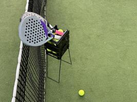 sfondo di padel racchetta e palla su artificiale erba pavimento nel all'aperto Tribunale. superiore Visualizza. foto