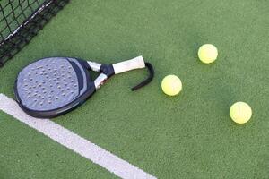pagaia tennis racchetta, palla e netto su il erba foto
