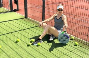 contento femmina pagaia tennis giocatore durante pratica su all'aperto Tribunale. copia spazio. foto