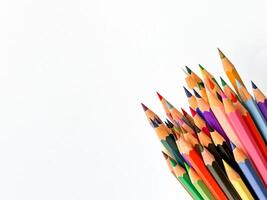 assortito affilato colorato matite puntamento su su bianca sfondo con copia spazio per testo. concetto di artistico o scuola forniture per disegno, insegnamento e educativo scopi. foto