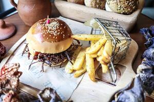 delizioso Hamburger e francese patatine fritte su taglio tavola foto