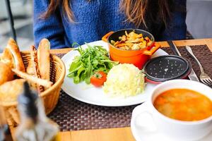 donna seduta a tavolo con piatto di cibo foto