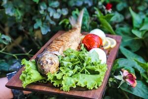 di legno taglio tavola con lattuga e pesce foto