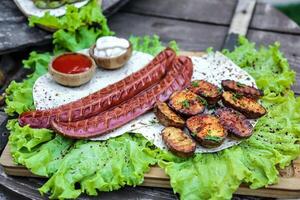 piatto di salsicce e patate su lattuga foto