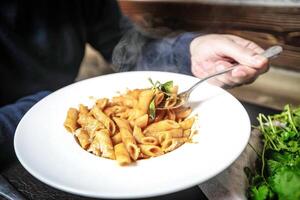 persona Tenere piatto di cibo su tavolo foto