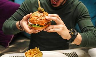 uomo Tenere grande Hamburger con salamoia foto