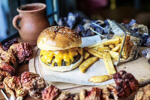 classico hamburger al formaggio e patatine fritte su vassoio foto