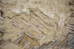 Close up di cracking muro di adobe texture, muro di argilla da una casa di fango. foto