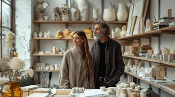 uomo e donna nel maglione In piedi nel ceramica laboratorio e Guarda a il scaffali con vasi e vasi. foto