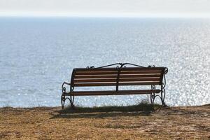 vuoto panchina su scogliera prima mare sfondo, tranquillo, calmo e silenzioso posto per pensiero solo foto