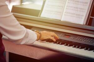 donna giochi elettrico pianoforte a all'aperto musica prestazione, vicino su Visualizza per agile mani foto